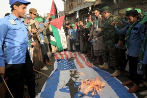 Des gens ont incendié un drapeau israélien et américain dans les rues de Sanaa, la capitale du Yémen tenue par les Houthis, pour montrer leur soutien aux Palestiniens, le 7 octobre 2023, lors d'un rassemblement de soutien aux Palestiniens après que le groupe militant Hamas a lancé une grande surprise. attaque à grande échelle contre Israël, le 7 octobre 2023. Au moins 70 personnes auraient été tuées en Israël, tandis que les autorités de Gaza ont publié un bilan de 198 morts lors de l'escalade la plus sanglante du conflit au sens large depuis mai 2021, avec des centaines d'autres blessés des deux côtés.  (Photo de MOHAMMED HUWAIS / AFP) (Photo de MOHAMMED HUWAIS/)