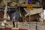 Un homme se tient devant un magasin endommagé à Tel Aviv, après qu'il ait été touché par une roquette tirée par des militants palestiniens depuis la bande de Gaza, le 7 octobre 2023.