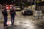 Les forces de sécurité israéliennes se tiennent le long d'une rue jonchée de débris à Tel Aviv après qu'elle a été touchée par une roquette tirée par des militants palestiniens depuis la bande de Gaza, le 7 octobre 2023. Le groupe militant palestinien Hamas a lancé une attaque surprise à grande échelle contre Israël le 7 octobre 2023. 7, 2023.