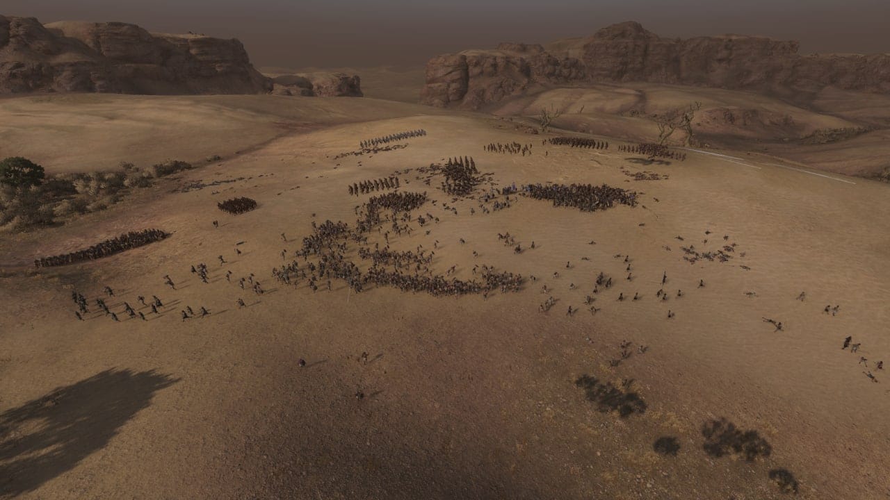 Revue de Total War Pharaoh : Une bataille désorganisée entre deux armées s'étend sur les dunes de sable.