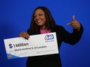 Marie Andrée Sanon détient son chèque d'un million de dollars après avoir gagné le billet boule d'or du Lotto 6/49 du 23 août 2023. 