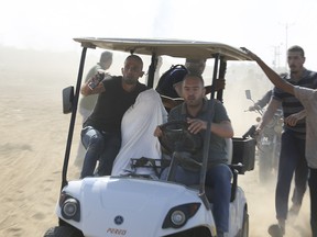 Des Palestiniens transportent un civil israélien capturé