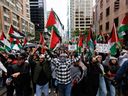 Des gens brandissent des drapeaux palestiniens lors d’une manifestation à Toronto, le 9 octobre 2023.  