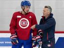 Le capitaine des Canadiens Nick Suzuki et l'entraîneur-chef Martin St-Louis discutent pendant le camp d'entraînement.