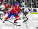 Le défenseur des Canadiens Kaiden Guhle patine entre Marcus Johansson, à gauche, du Wild, et Kirill Kiprizov pour chasser une rondelle libre mardi soir avant de quitter le match avec une blessure apparente au poignet.