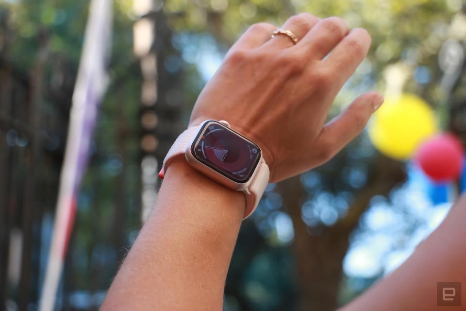 Photo d'une personne portant l'Apple Watch Series 9 au poignet gauche.  La photo est cadrée de la main à l’avant-bras tandis que la personne lève son poignet pour voir le cadran de la montre.