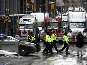 Des policiers patrouillent à pied le long de la rue Albert alors qu'une manifestation contre les restrictions liées à la COVID-19, marquée par des embouteillages et le bruit des klaxons des camions, a atteint son 14e jour, à Ottawa, le jeudi 10 février 2022.