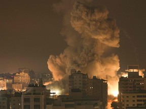 Le feu et la fumée s'élèvent au-dessus des bâtiments de la ville de Gaza lors d'une frappe aérienne israélienne, le 8 octobre 2023.