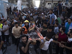 Des Palestiniens transportent une personne blessée