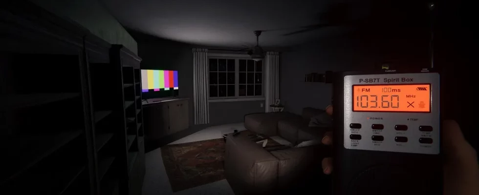 Phasmophobia: the player holding a spirit box while stood in a living room.