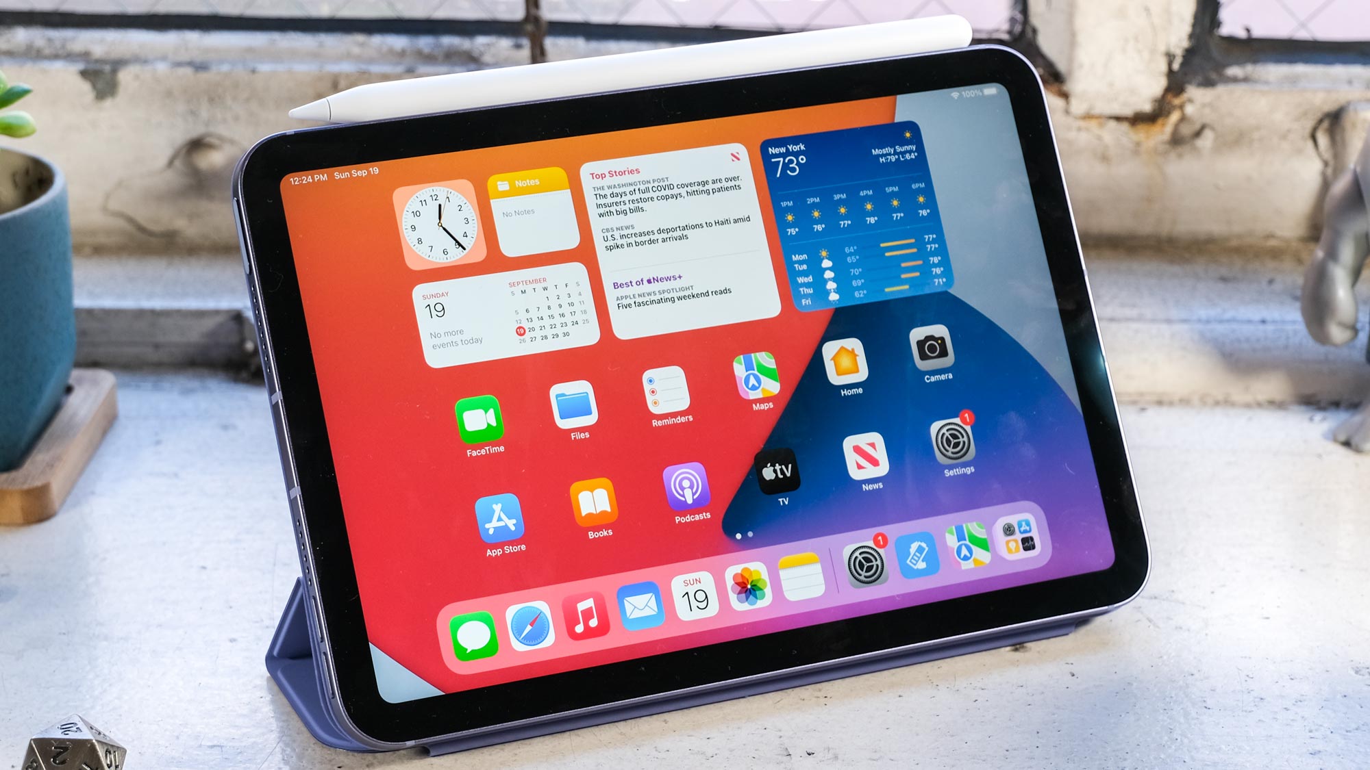 L'iPad mini 2021 avec Apple Pencil (gen 2) et un étui Apple Smart Folio violet sur un bureau
