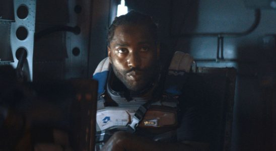 John David Washington sits waiting for action in a transport in The Creator.