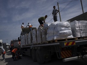 Des camions transportant de l'aide humanitaire pour la bande de Gaza arrivent d'Égypte à Rafah le samedi 21 octobre 2023. Un Canadien coincé à Gaza affirme que les premiers camions d'aide sont entrés dans l'enclave aujourd'hui depuis le début de la dernière guerre entre Israël et le Hamas il y a deux semaines. fera à peine une brèche dans la crise humanitaire que vivent les Palestiniens tout autour de lui.LA PRESSE CANADIENNE/AP/Fatima Shbair