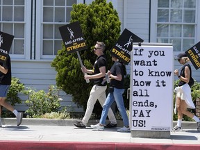 Les piqueteurs portent des pancartes devant les studios Amazon à Culver City, en Californie, le lundi 17 juillet 2023.