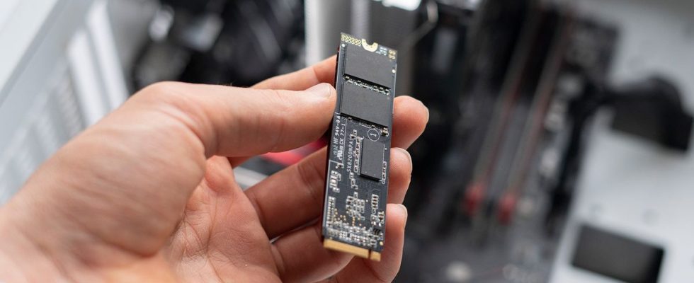 person holding new modern fast ssd m2 drive to replace it on computer