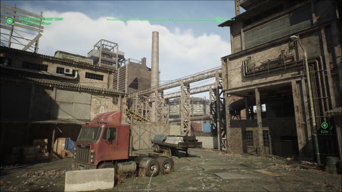 Une capture d'écran de RoboCop : Rogue City, montrant une aciérie délabrée.  La cabine d'un camion se trouve au premier plan, entourée de structures en briques et d'une cheminée industrielle.