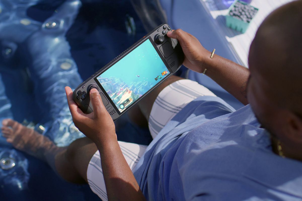 Une personne tenant le Steam Deck OLED, qui joue Dave le Plongeur.  Ironiquement, la personne qui tient la console est dans une piscine, ce qui correspond au fait que vous êtes dans l'eau dans le jeu.