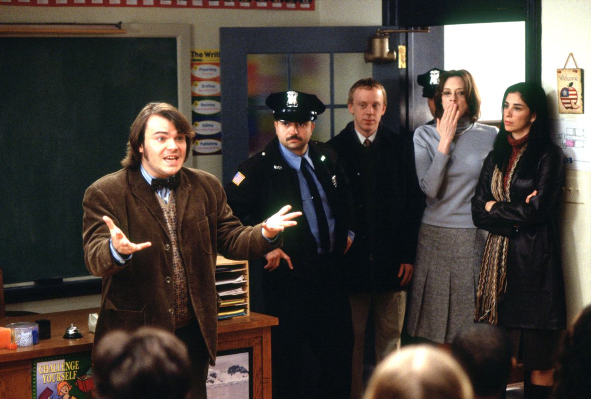 Jack Black, vêtu d'une veste de costume en tweed marron, lance un appel vocal à sa classe en tant que flic et plusieurs administrateurs entrent dans la salle dans le film School of Rock de Richard Linklater en 2003.