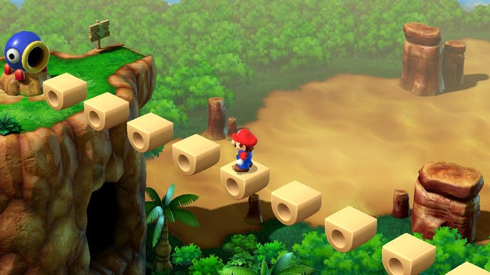 Mario traverse un pont au-dessus d'une petite chute dans cet écran de Super Mario RPG.  Un canon l'attend au fond.