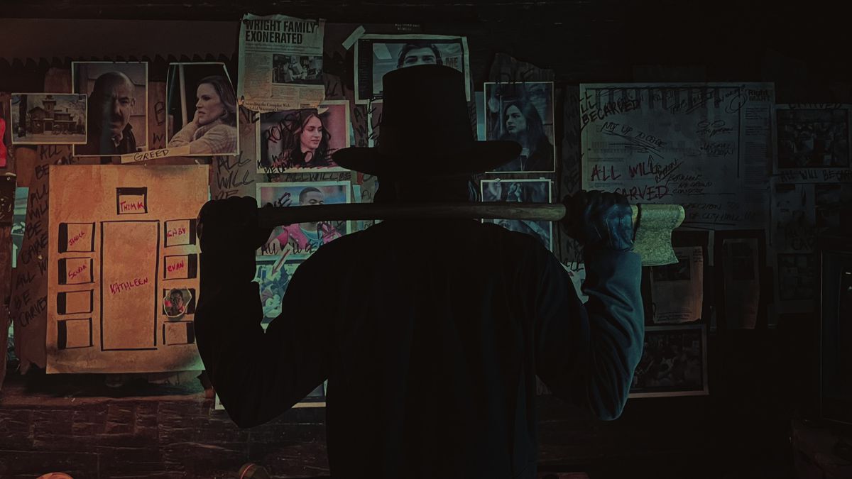 Un homme avec un chapeau tenant une hache fait face à un mur couvert de photos du film Thanksgiving