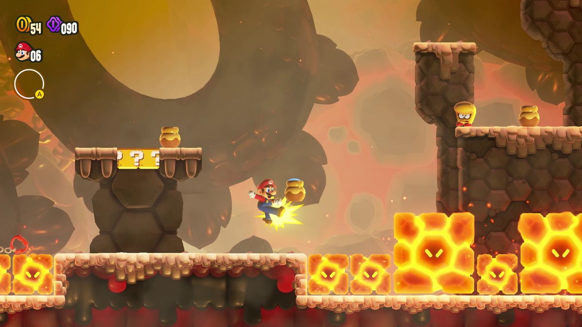 Mario donne un coup de pied dans un pot en argile vers un tas de pierres chaudes, sous le regard d'un Morocon, dans une capture d'écran de Super Mario Bros. Wonder