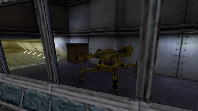 Half-Life : un gros robot jaune porte une caisse d'apparence lourde.