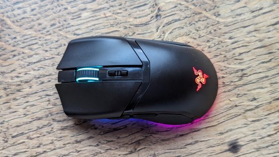 Test Razer Cobra Pro : une souris noire avec RGB multicolore apparaît sur une surface en bois.