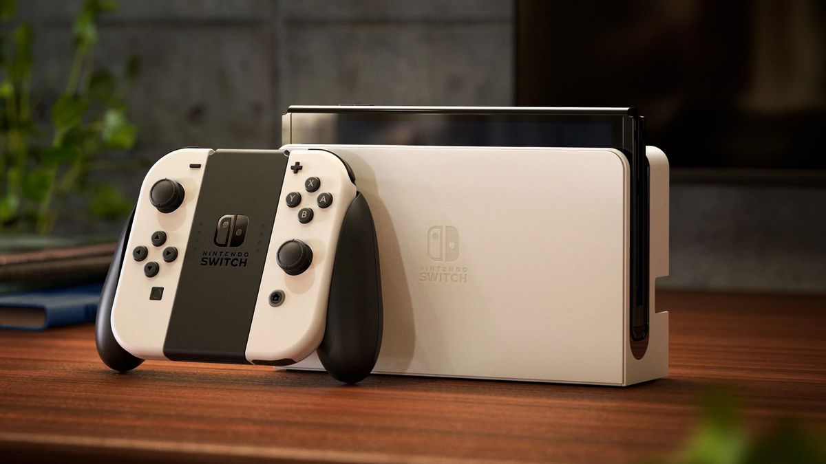 Une photo de la Nintendo Switch (modèle OLED) en blanc sur une table en bois