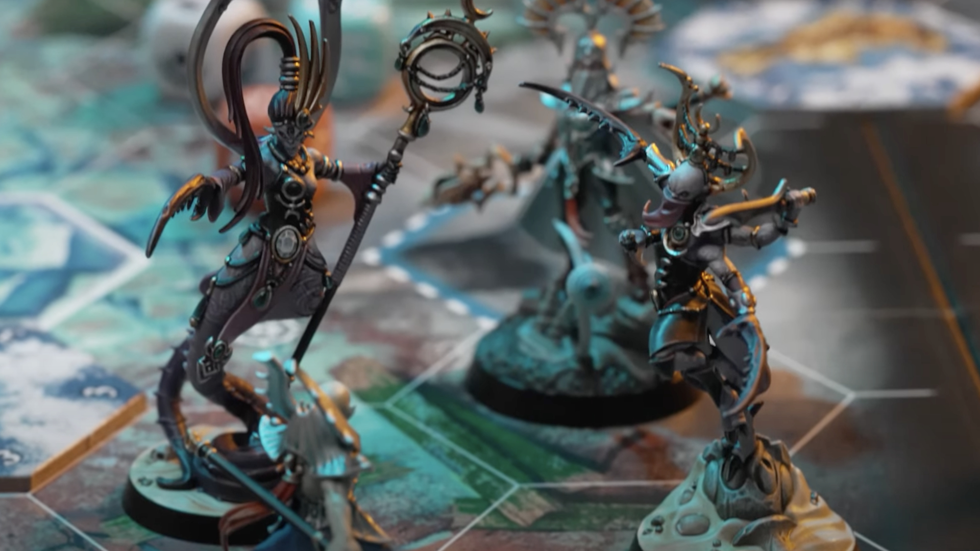 Deux démons de Slaanesh se rassemblent avec un Ioneth Deepkin derrière eux sur le plateau de Warhammer Underworlds: Deathgorge.