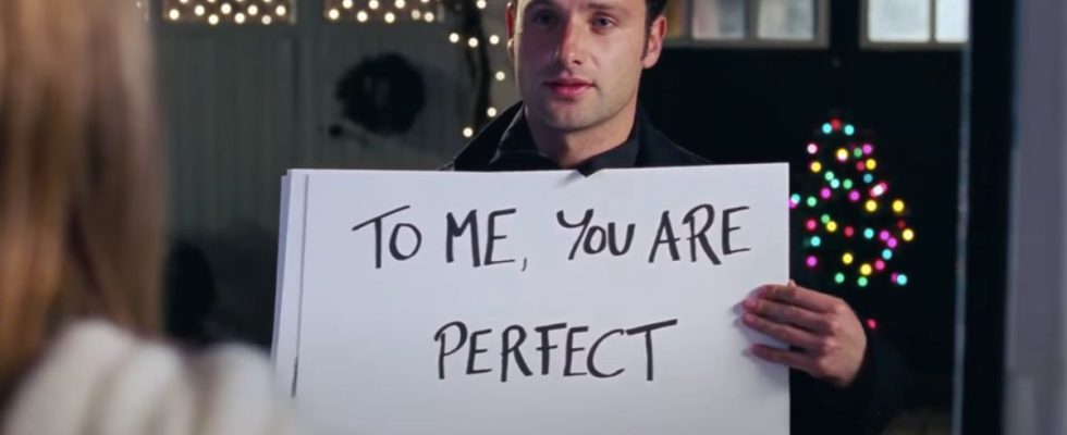 Andrew Lincoln stands with his cue cards in front of Keira Knightley in Love Actually.