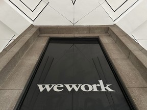 Un logo WeWork sur un immeuble à New York.  La perte de loyers suite au départ de WeWork va faire grimper la valeur des bâtiments qu'ils laissent derrière eux.