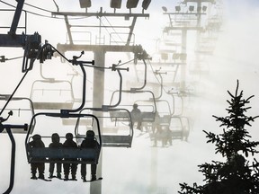 Les skieurs et planchistes montent sur les premières chaises lors de la journée d'ouverture au Parc olympique du Canada à Calgary, en Alberta, le vendredi 24 novembre 2023.