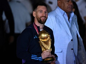 Le capitaine et attaquant argentin Lionel Messi détient le trophée de la Coupe du Monde de la FIFA.