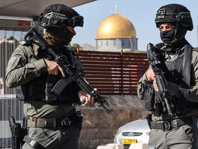 Les forces de sécurité israéliennes bloquent une rue alors que des Palestiniens participent aux prières du vendredi midi dans le quartier de Ras al-Amud à Jérusalem-Est, le 24 novembre 2023.