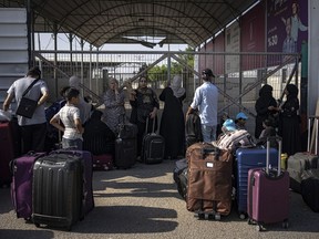 Des Palestiniens attendent de passer la frontière égyptienne à Rafah, dans la bande de Gaza, le mercredi 1er novembre 2023.