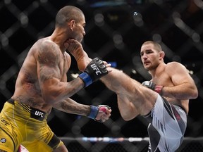 Sean Strickland, à droite, donne un coup de pied à Alex Pereira dans un combat de poids moyen lors de l'événement d'arts martiaux mixtes UFC 276, le samedi 2 juillet 2022, à Las Vegas.
