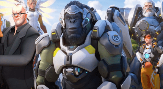 Greg Davies, a british comedian in Taskmaster VR, stands next to the heroes of Overwatch 2 assembled in a triumphant formation.