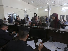 Les Palestiniens ayant la double nationalité s'enregistrent pour passer la frontière vers l'Égypte du côté de la bande de Gaza au poste frontière de Rafah, le jeudi 2 novembre 2023.