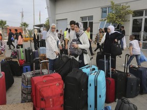 Des Palestiniens arrivent au poste frontière égyptien à Rafah, dans la bande de Gaza, le lundi 13 novembre 2023. Les Canadiens qui ont fui la bande de Gaza veulent désespérément aider la famille qu'ils soutiennent, mais disent que la définition canadienne de la famille signifie que la vie de leurs proches est en danger pour une durée indéterminée.
