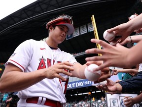 Shohei Ohtani des Los Angeles Angels signe des autographes lors de la journée d'entraînement Gatorade All-Star au T-Mobile Park, le lundi 10 juillet 2023, à Seattle.