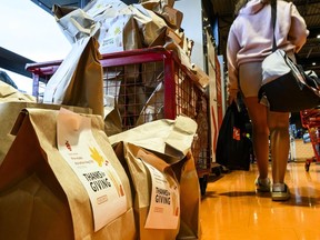 Un chariot déborde de sacs de nourriture pré-remplis lors d'une collecte de nourriture de Thanksgiving pour la Banque alimentaire d'Ottawa dans une épicerie d'Ottawa, le samedi 7 octobre 2023.