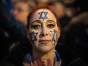 Une femme portant l'étoile de David a peint sur son visage des manifestations avec des membres de la communauté juive devant la BBC Broadcasting House à Londres pour manifester contre le refus persistant de la BBC de qualifier le Hamas de terroriste.