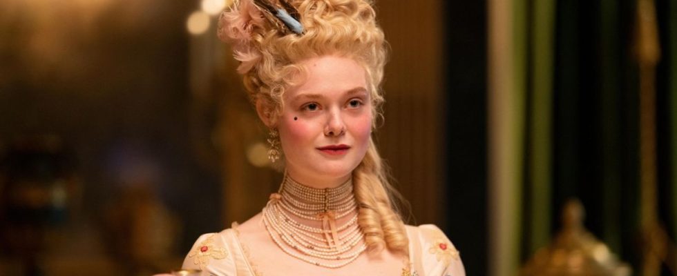 Elle Fanning as Catherine holding up a small glass in The Great.