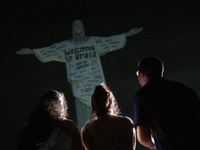 Des fans regardent la statue du Christ Rédempteur illuminée avec un message de bienvenue adressé à la chanteuse américaine Taylor Swift, à Rio de Janeiro, au Brésil, le jeudi 16 novembre 2023.