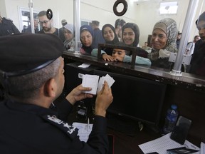 Les Palestiniens ayant la double nationalité s'enregistrent pour passer la frontière vers l'Égypte du côté de la bande de Gaza au poste frontière de Rafah, le jeudi 2 novembre 2023.
