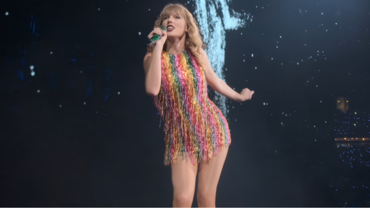 Taylor Swift dans une robe arc-en-ciel chantant lors de la tournée du Reputation Stadium.