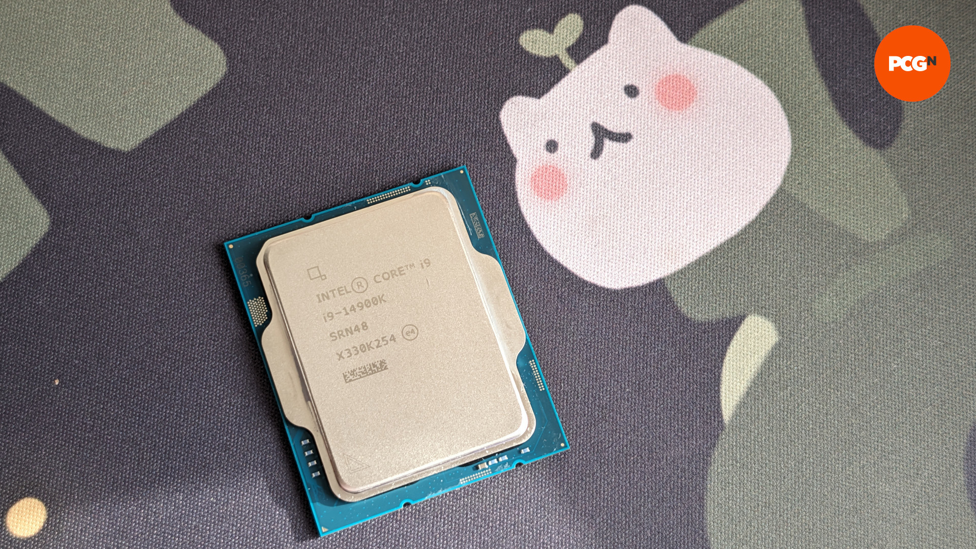 L'Intel Core i5 14900K (à gauche) sur un fond noir et feuillu, avec une silhouette en forme de chat (à droite)