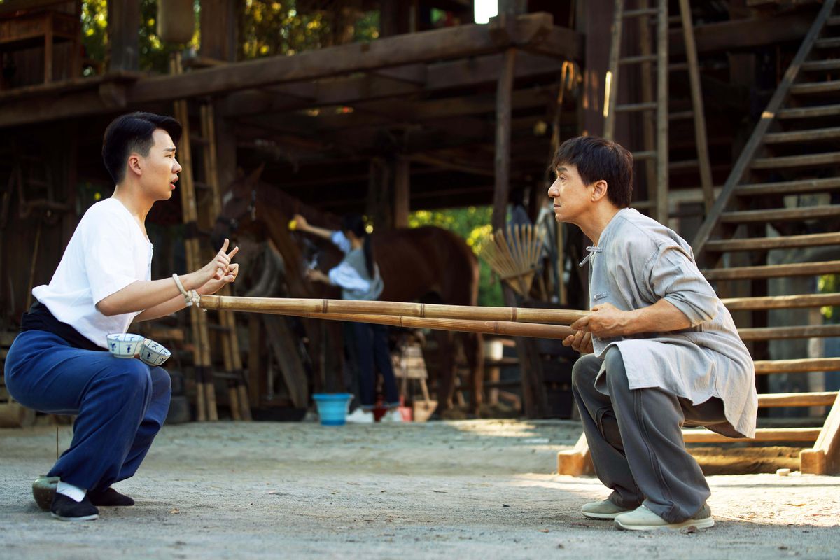 Jackie Chan et Kevin Guo effectuent des exercices accroupis intenses alors qu'un cheval se tient en arrière-plan dans Ride On.
