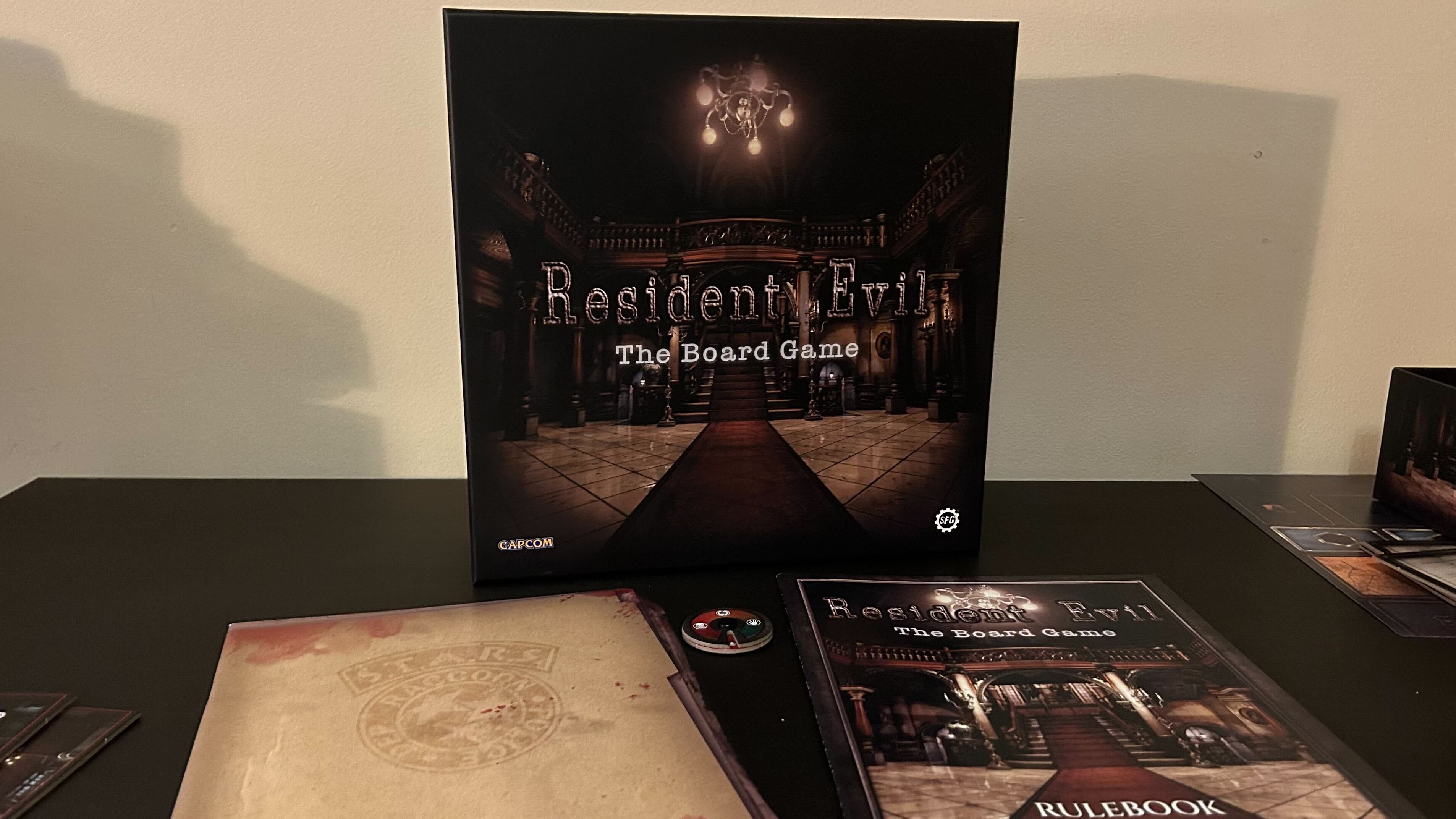 Resident Evil The Board Game fort et livres de règles sur une table noire