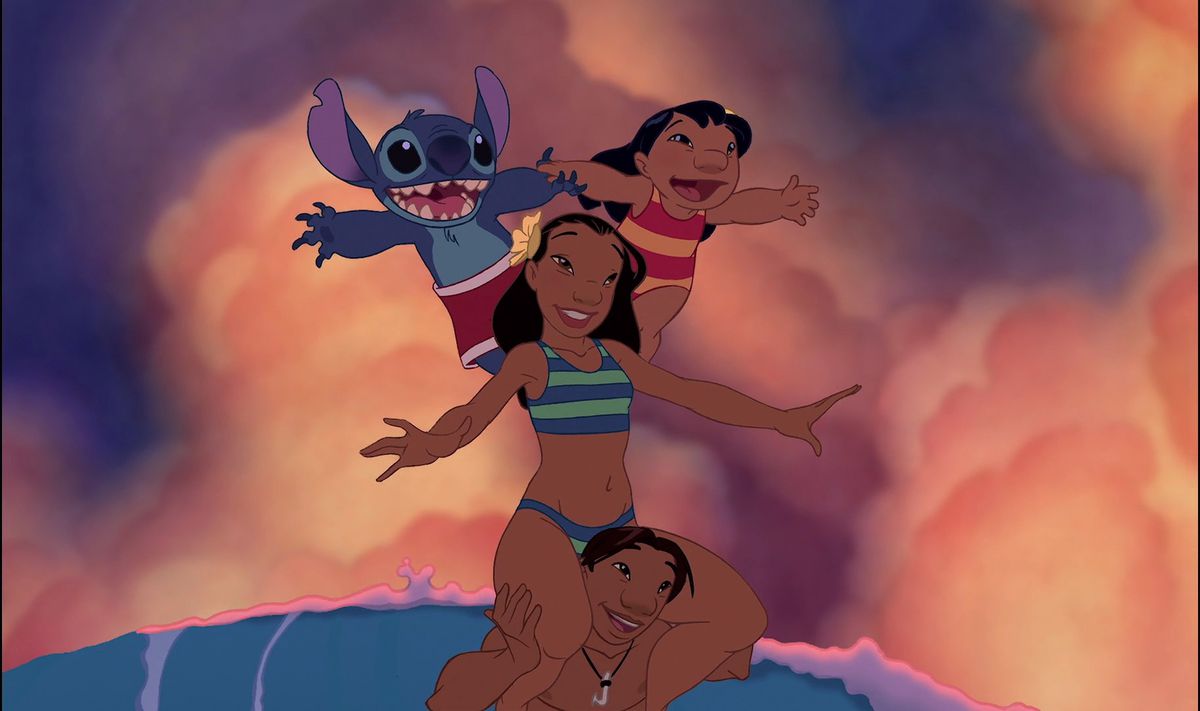 Lilo et Stitch en équilibre sur les épaules de Nani, tandis que Nani est en équilibre sur les épaules de David en surfant.